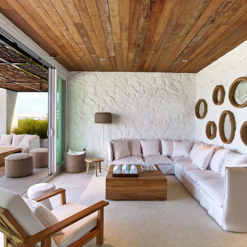 Modern living room with white sectional sofa, wooden ceiling, and walls decorated with circular mirrors.