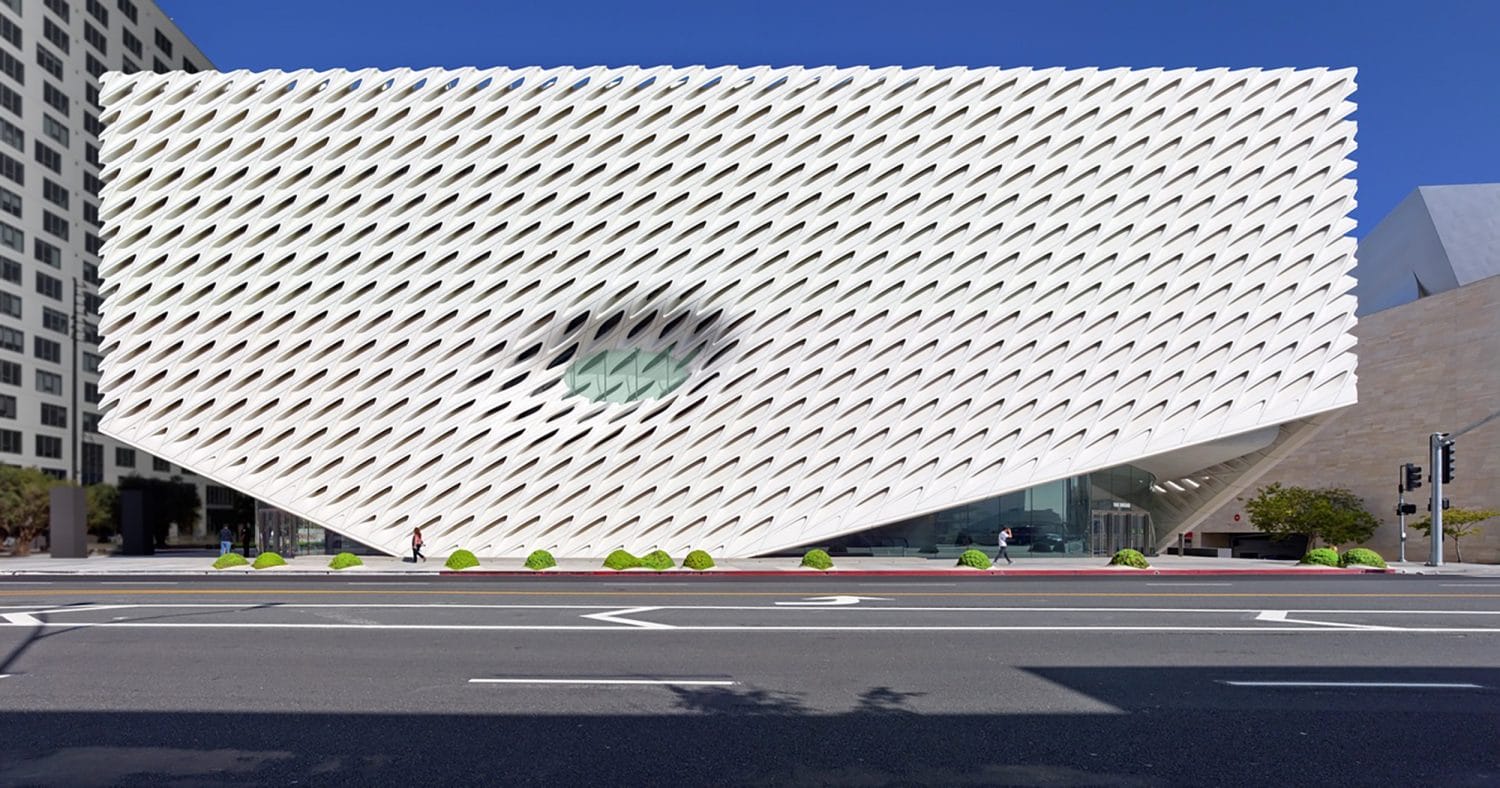 Modern architectural building with unique, honeycomb pattern exterior on a sunny day, situated in an urban setting.