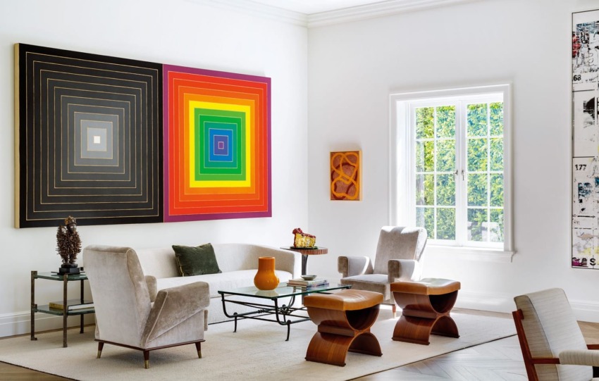 Modern living room with colorful geometric artwork, sleek furniture, and large window letting in natural light.