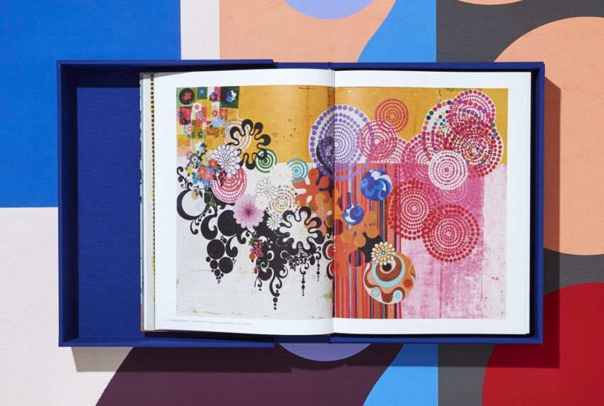 Open art book with colorful abstract designs and geometric patterns in a blue case on a multicolored background.