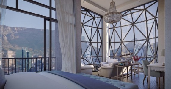 Luxury bedroom with city view, elegant furniture, and glass walls with mountain scenery.