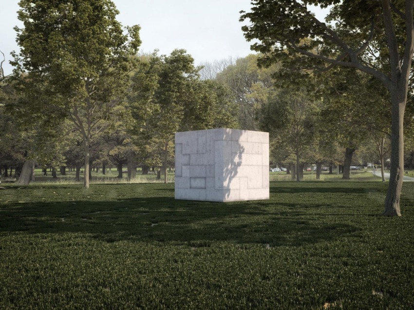 Concrete cube structure surrounded by trees and grass in a park setting under a clear sky.