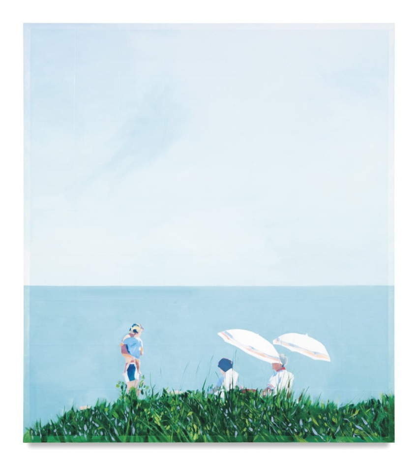 Three people in a grassy field with two umbrellas, overlooking a calm sea and clear blue sky in the background.