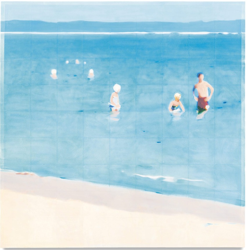 People swimming in a calm blue ocean near a sandy beach on a sunny day, with distant hills in the background.