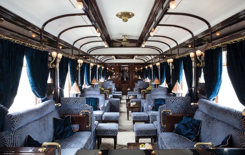 Luxurious vintage train interior with elegant seating, ornate wood paneling, and soft lighting creating a classic atmosphere.