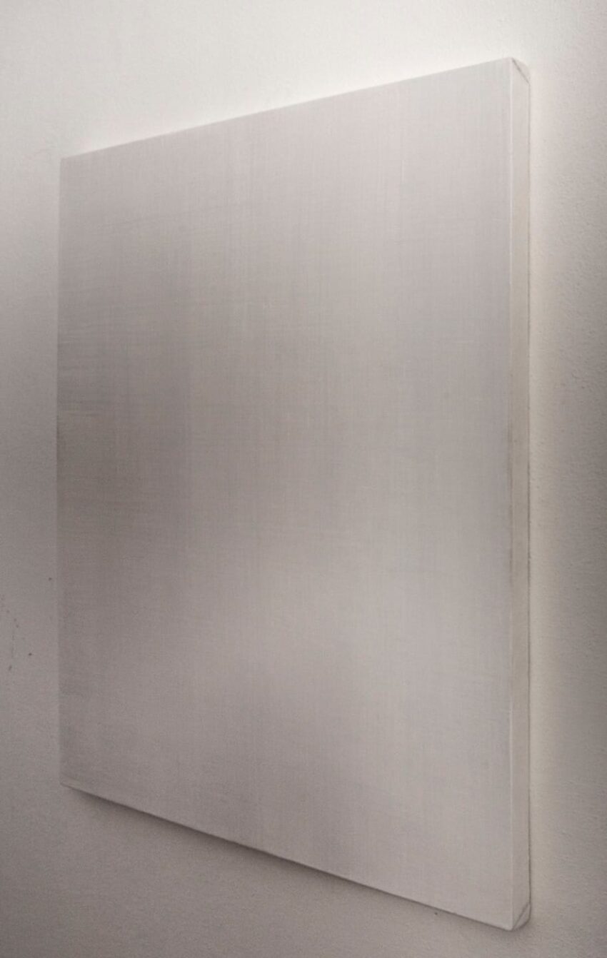 Blank white square canvas on a wall.