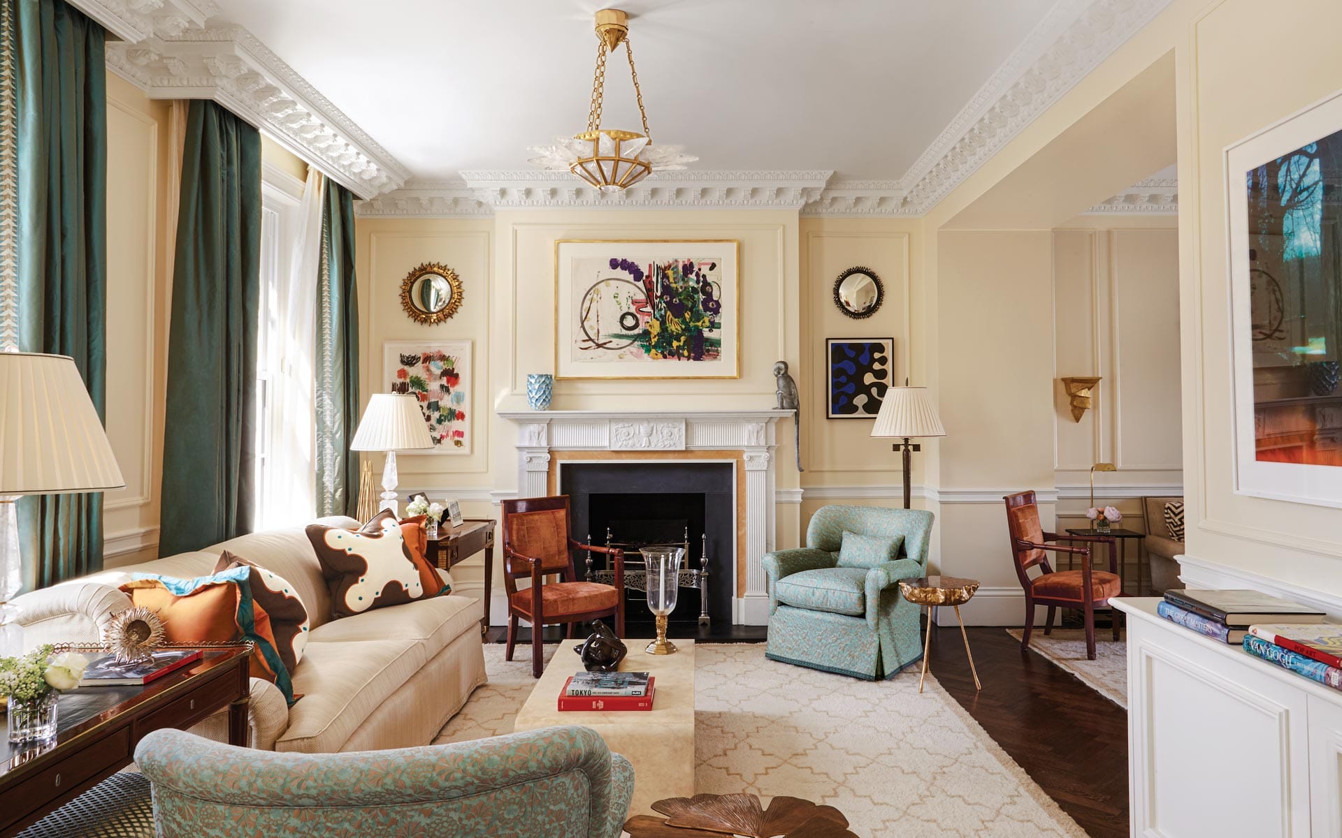 Elegant living room with classic decor, including plush sofas, armchairs, fireplace, and artistic wall decorations.