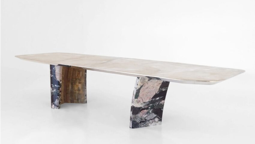 Modern marble dining table with a sleek rectangular top and two artistic patterned stone legs on a white background.