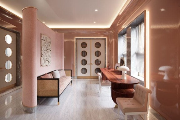 Luxurious room with pink walls, elegant wooden desk, cozy sofa, art piece, round door windows, and soft lighting.