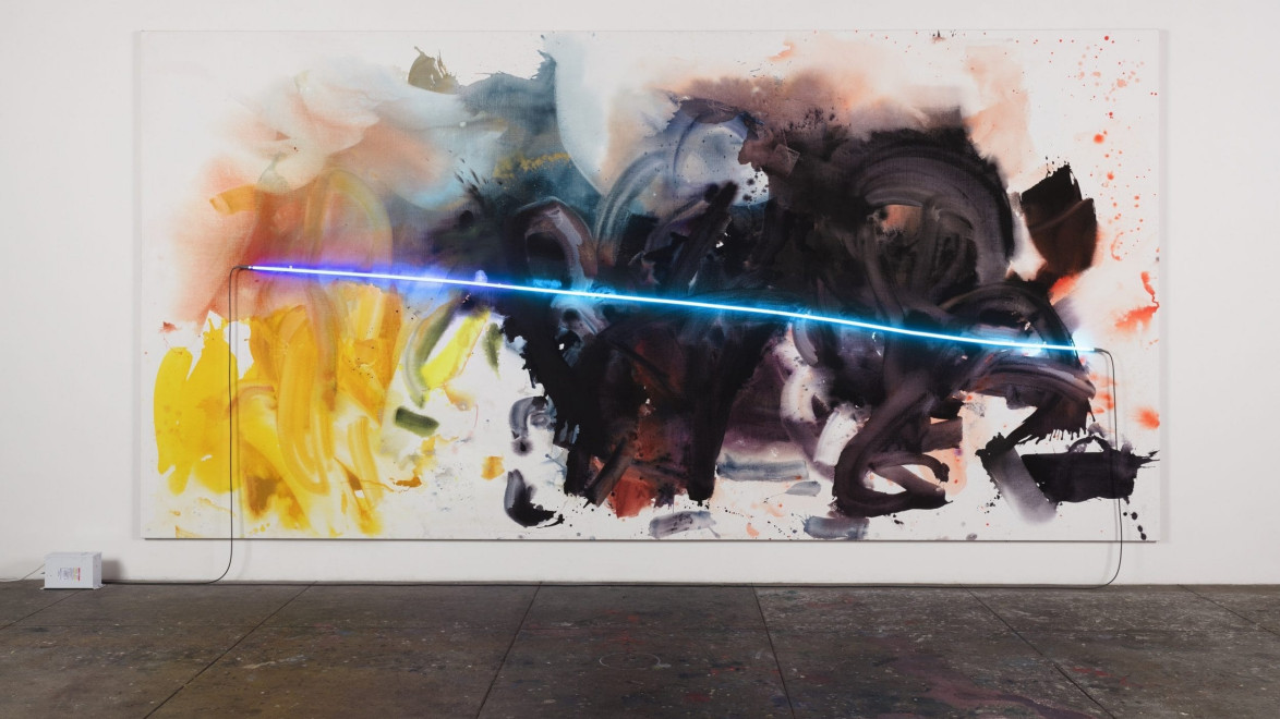 Abstract art with vibrant splashes of color and a blue neon light across the canvas, displayed on a gallery wall.