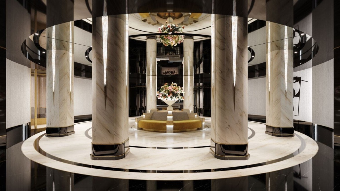 Luxurious hotel lobby with marble columns, elegant chandelier, floral arrangements, and stylish seating area.