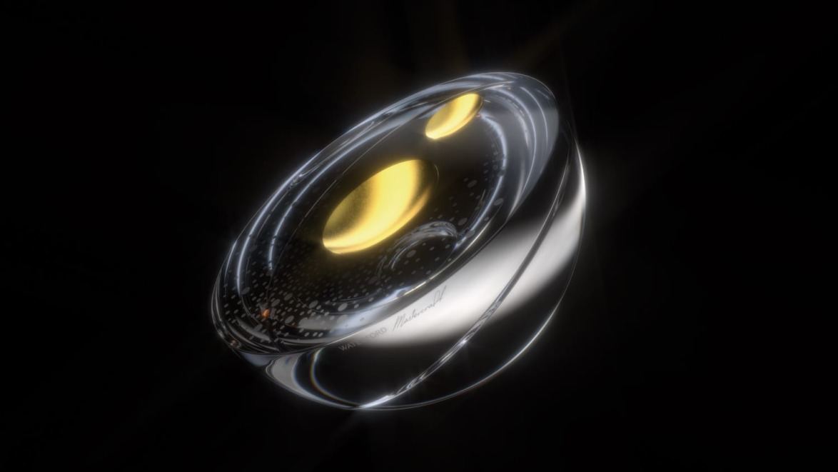 Futuristic glass and metal object with glowing yellow accents against a dark background.