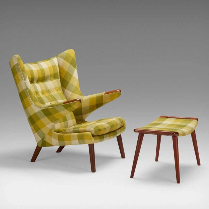 Green plaid wingback chair with matching ottoman on a light gray background.