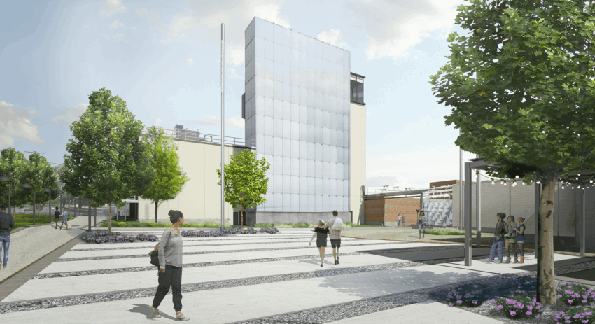 Modern building with glass facade, surrounded by trees and people walking on a patterned pathway under a partly cloudy sky.