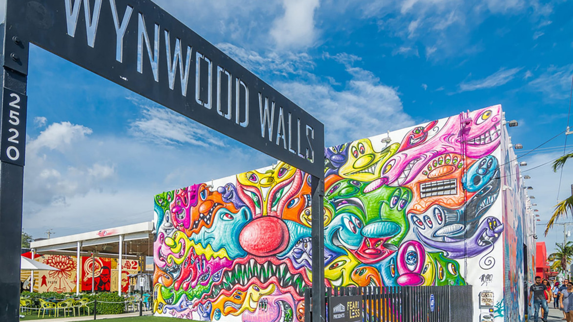 Colorful graffiti murals at Wynwood Walls, Miami, showcasing vibrant street art against a bright blue sky in an urban setting.