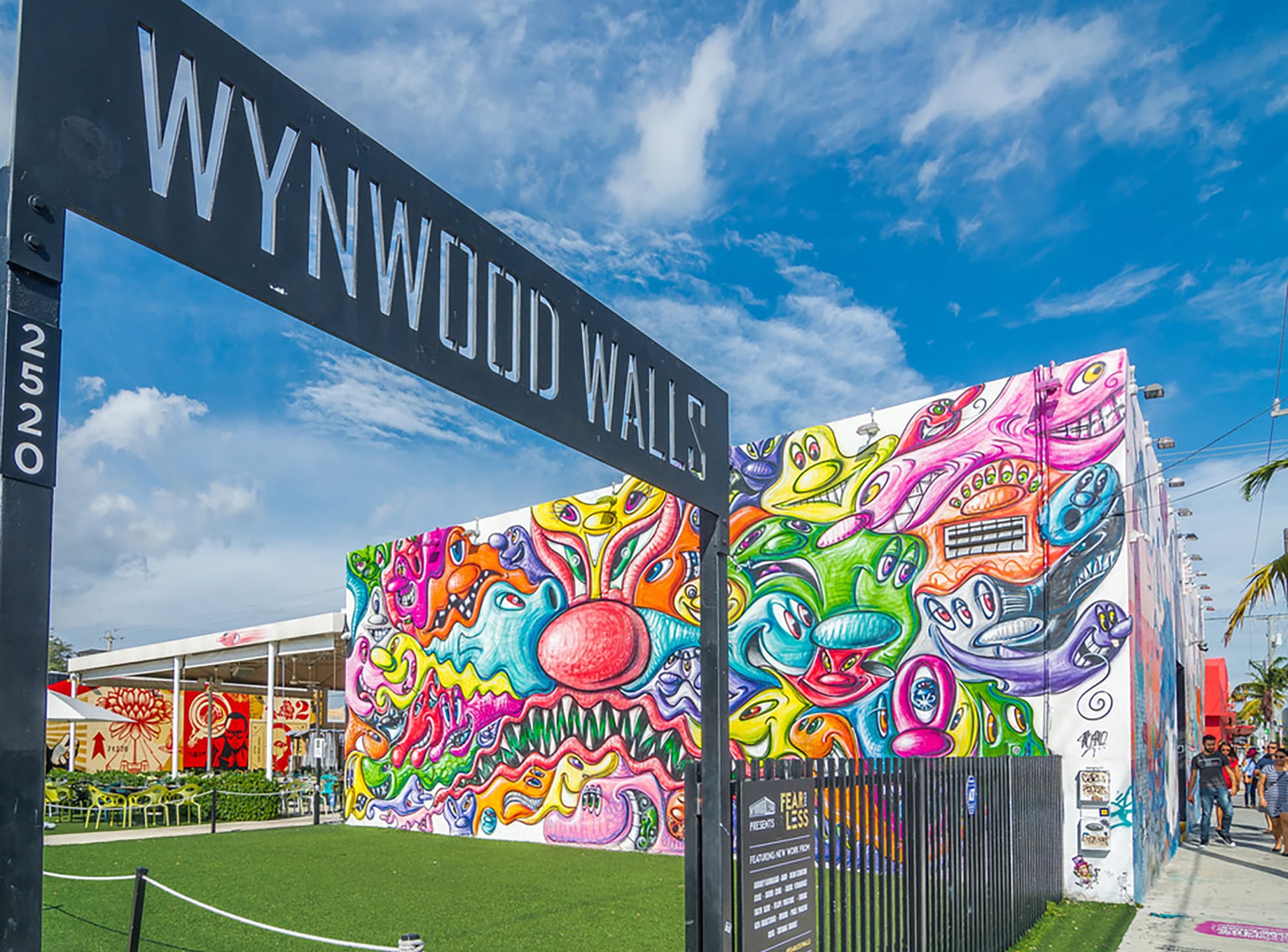 Colorful graffiti murals at Wynwood Walls, Miami, showcasing vibrant street art against a bright blue sky in an urban setting.