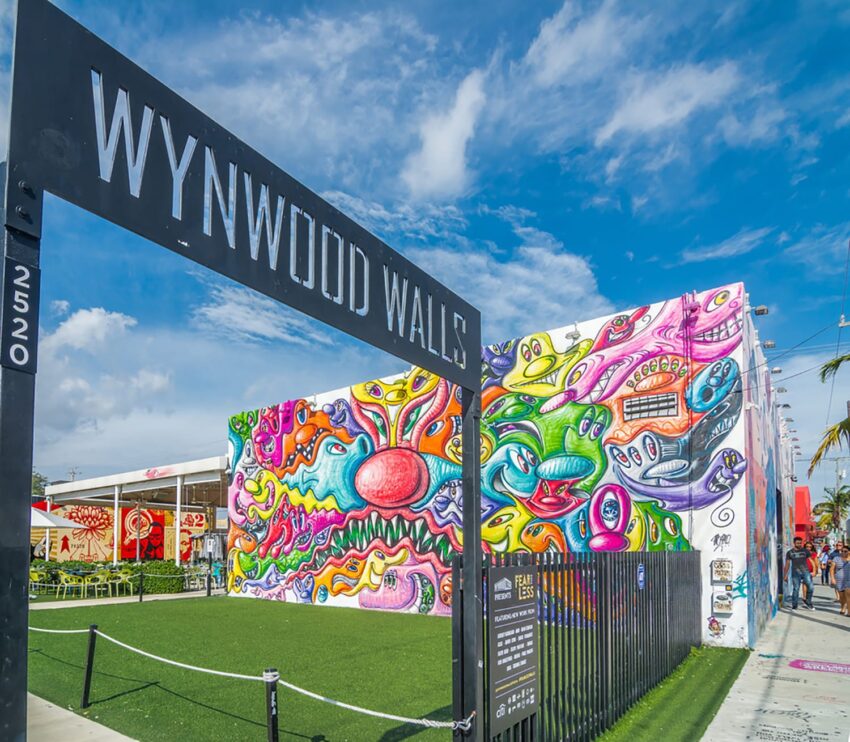 Colorful murals at Wynwood Walls in Miami with a clear blue sky.