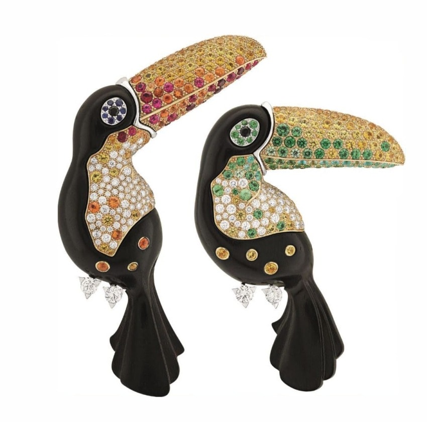 Two decorative toucan figures adorned with colorful gemstones, featuring vibrant beaks and detailed plumage designs.