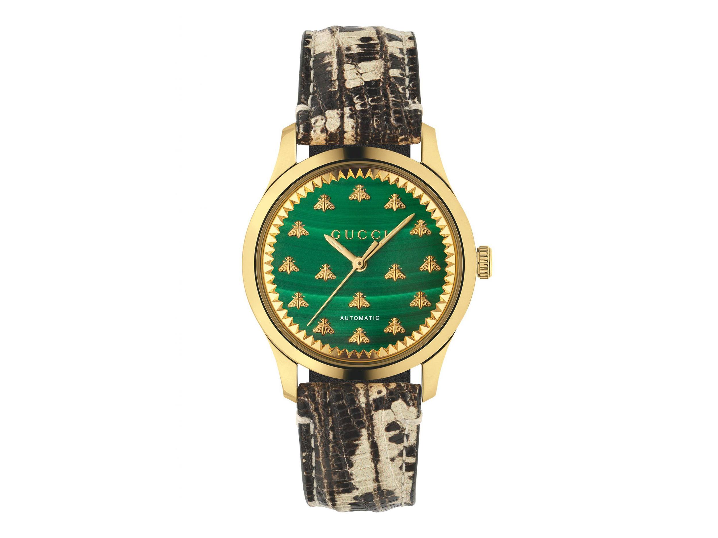 Gold wristwatch with green face featuring bee motifs and a textured brown strap.