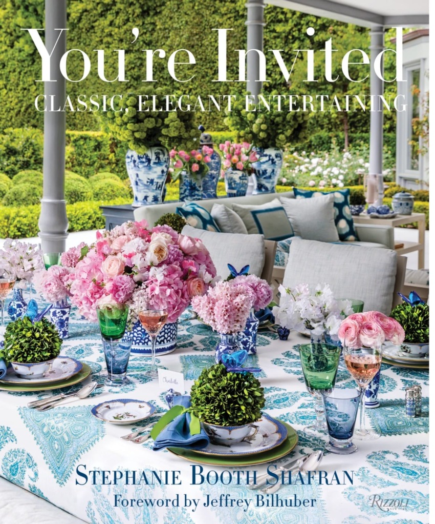Elegant outdoor dining setup with colorful floral arrangements and place settings in a garden setting, cover of entertaining book