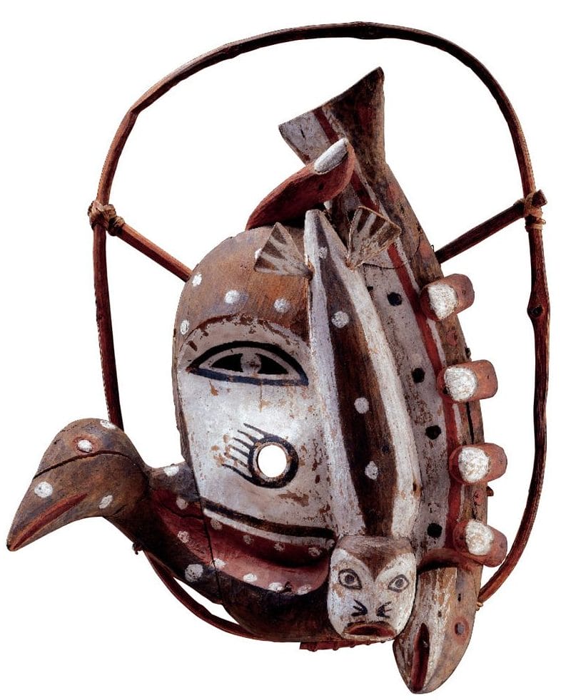 African wooden mask with polka dot patterns, featuring a bird and fish design, mounted on a curved wooden frame.