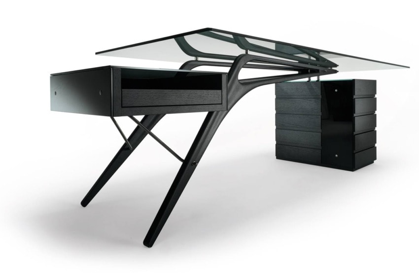 Modern black glass-top desk with sleek legs and attached drawers on a white background.
