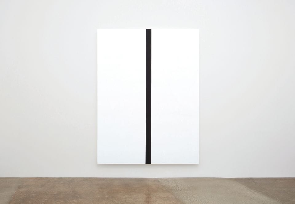 Minimalist artwork featuring a large white canvas divided by a single vertical black line placed in a gallery setting.