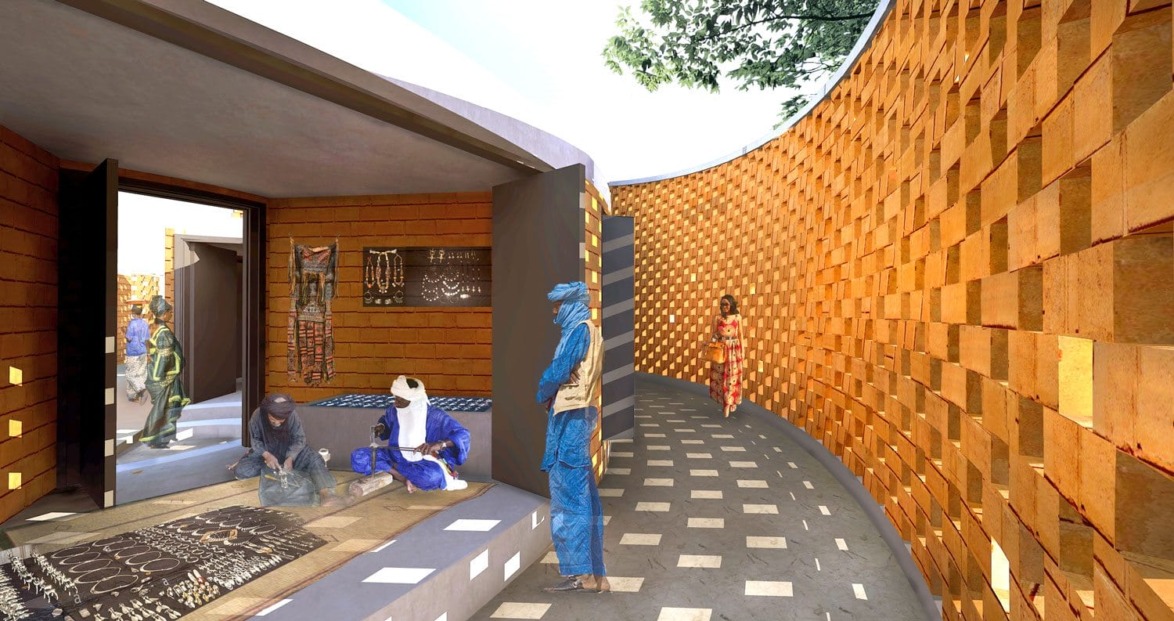 Curved brick walkway with people viewing art and crafts in a sunlit, open gallery setting.