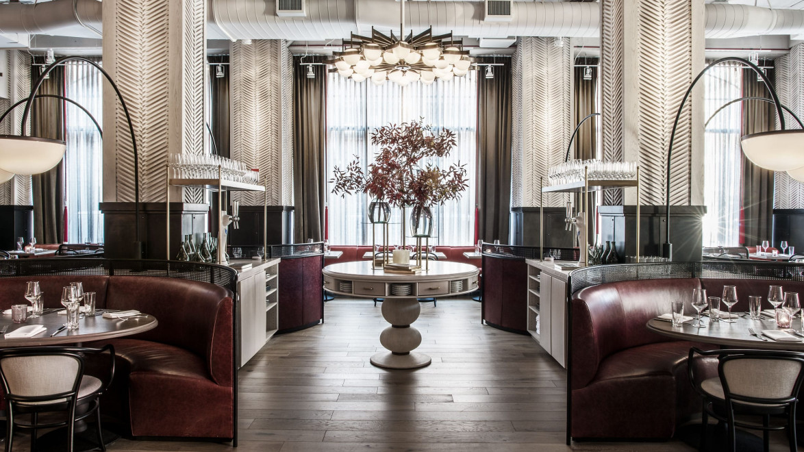 Luxurious restaurant interior with elegant round booths, a central table with floral arrangement, and modern lighting fixtures.