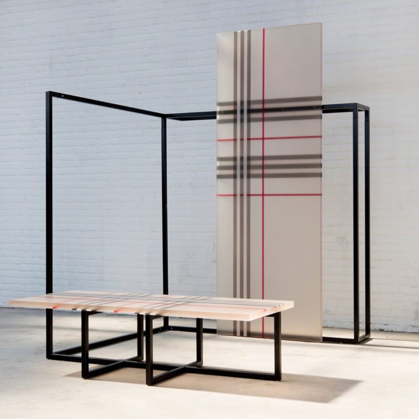 Modern art installation with geometric patterns and intersecting lines on panels and tables in a minimalist space.