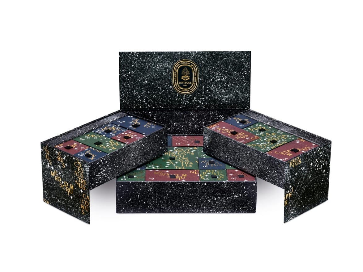 Luxury puzzle box set with multiple sections, embossed with gold and colored pieces on a speckled black background.