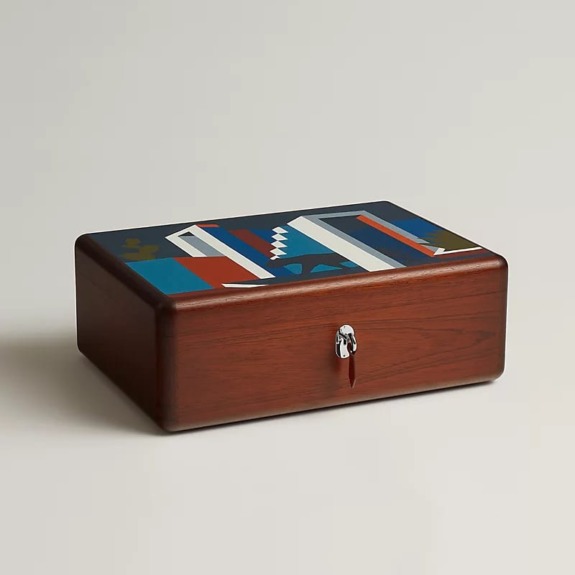 Wooden box with abstract geometric design on its lid and a metal lock at the front.