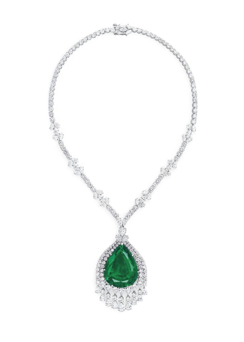 Elegant silver necklace with a large teardrop-shaped green gemstone pendant, adorned with smaller clear gemstones.