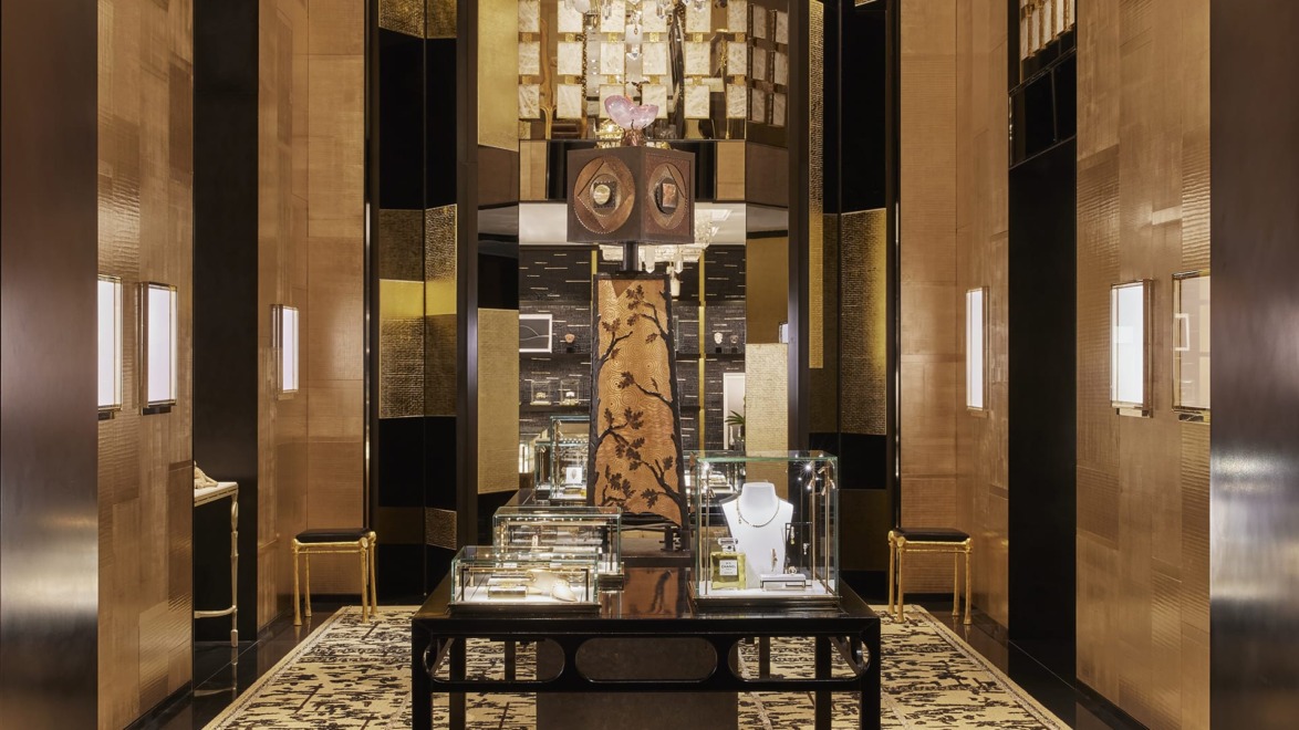 Luxury jewelry store interior with elegant decor, glass display cases, ornate chandelier, and plush carpeting.