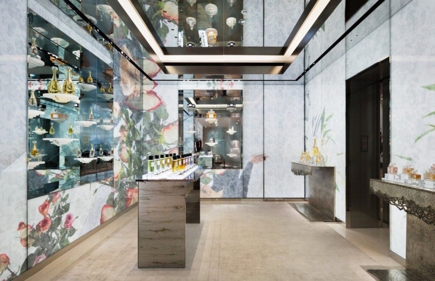 Luxurious boutique interior with floral wall designs, stylish modern decor, and various elegant perfume displays.