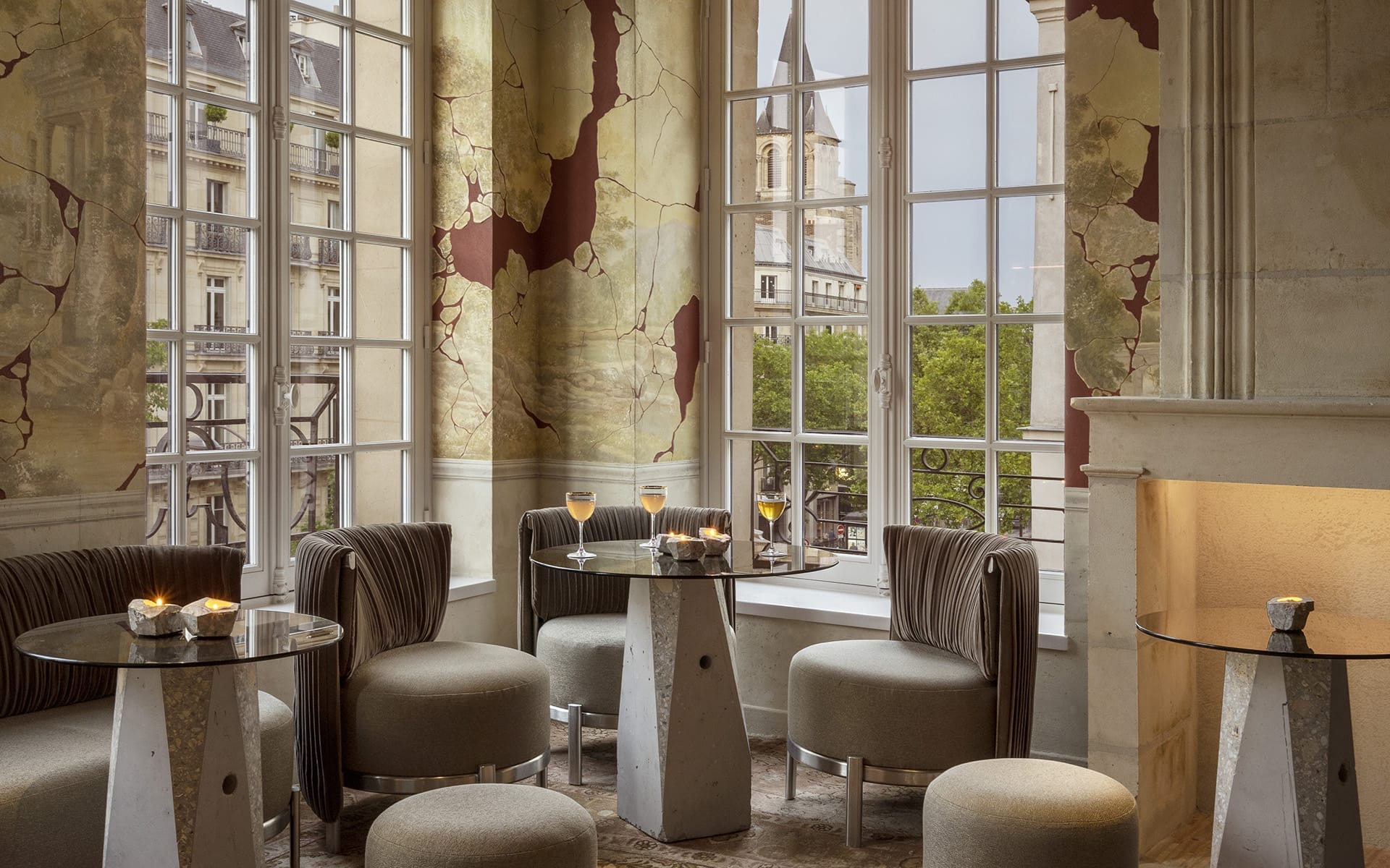 Elegant cafe with modern tables and chairs, large windows revealing a city view, and warm ambient lighting.