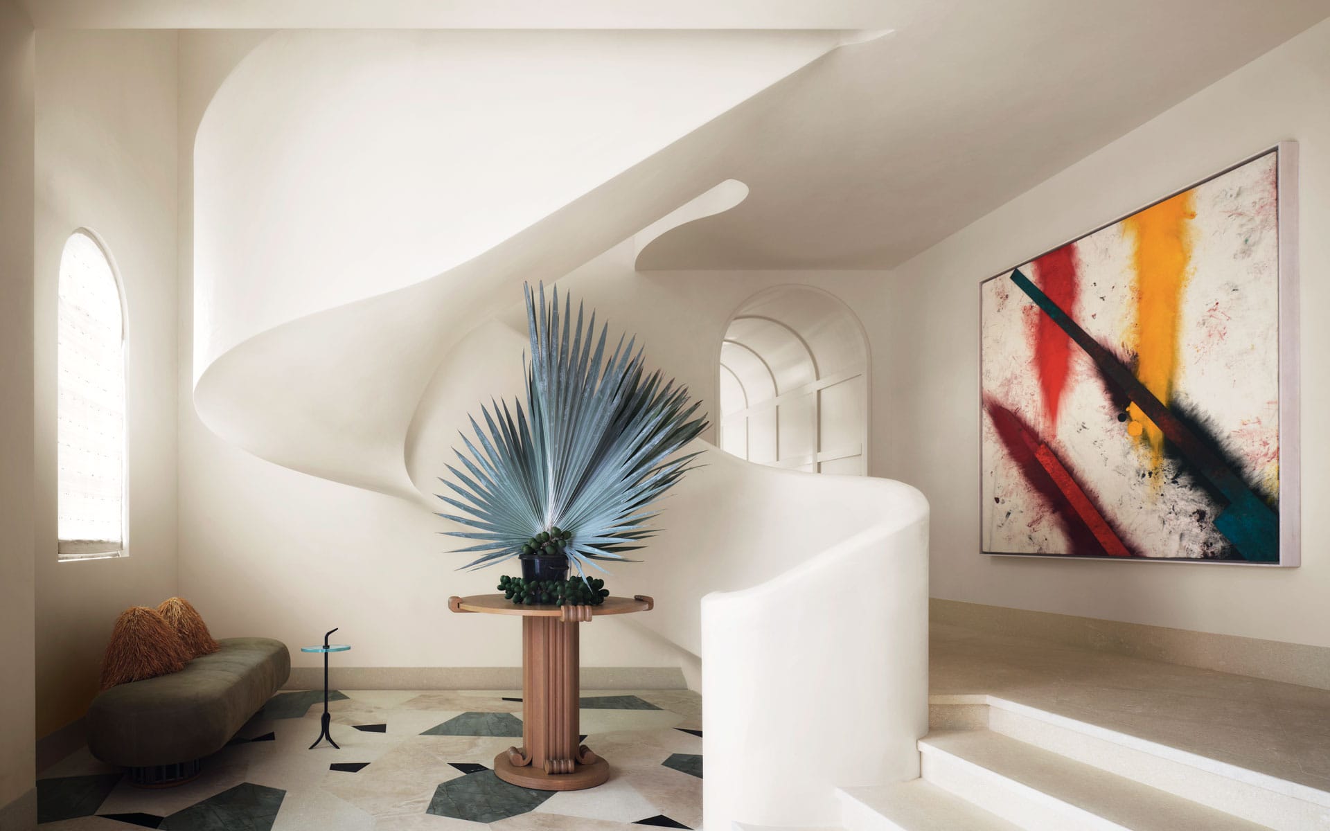 To make an instant impression, designer Jessica Schuster conceived a spiraling staircase and a lively stone floor for the entry of her parents’ Palm Beach, Florida, home, which she created in collaboration with Smith and Moore Architects. A painting by Sterling Ruby overlooks the space, where a sofa by Khaled El Mays joins a small glass-top table by Leo Sentou from the Invisible Collection and a custom limed-oak center table.