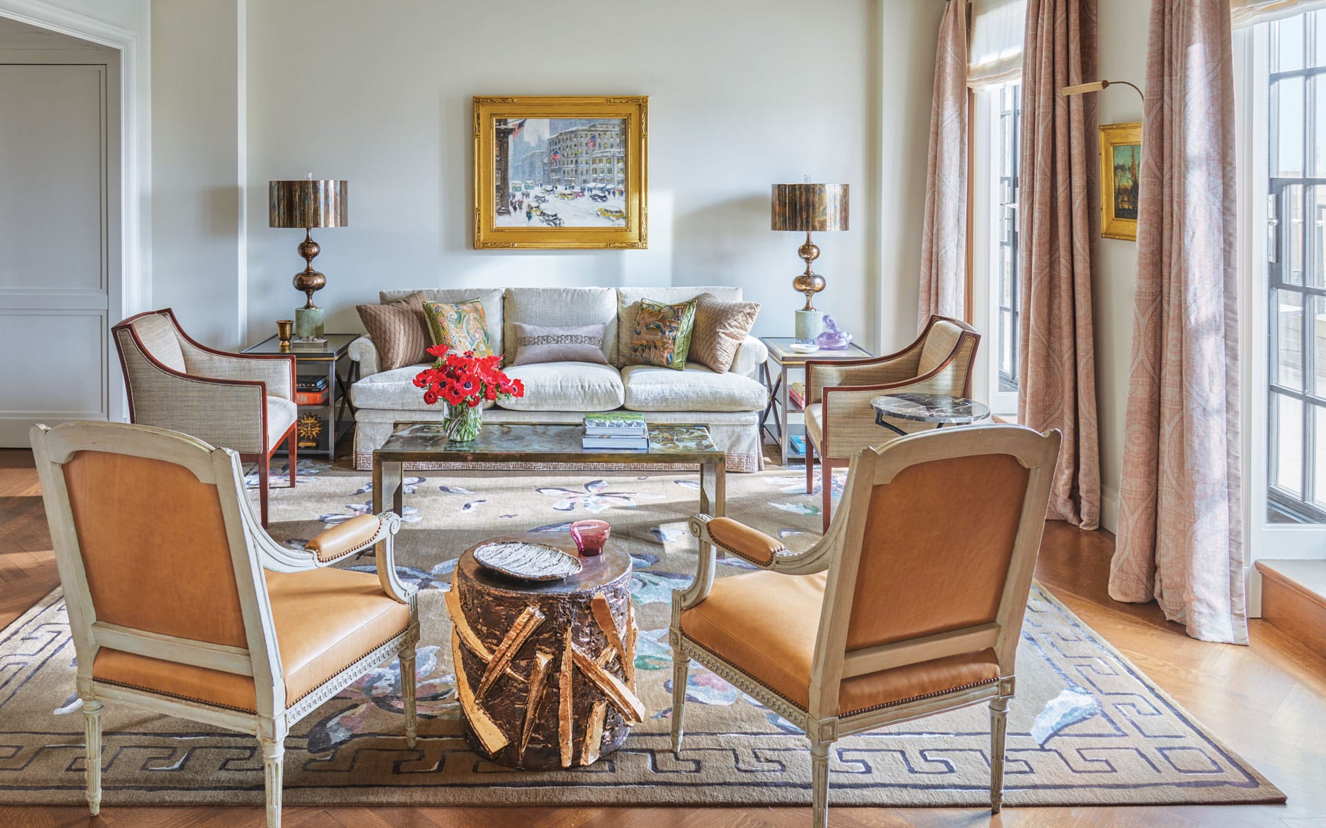 In the living room of an apartment that architect Lee Ledbetter designed for an art-collecting couple at The Carlyle hotel in New York, a Guy C. Wiggins painting overlooks a custom sofa flanked by 1940s French lounge chairs and a ’60s Philip and Kelvin LaVerne cocktail table. They are joined by brass lamps by Sylvan S.F., Louis XVI armchairs by Claude II Sene, and a Peter Lane ceramic drum table. A Paul Cornoyer painting hangs between the French doors, which are curtained in a Cowtan & Tout fabric.