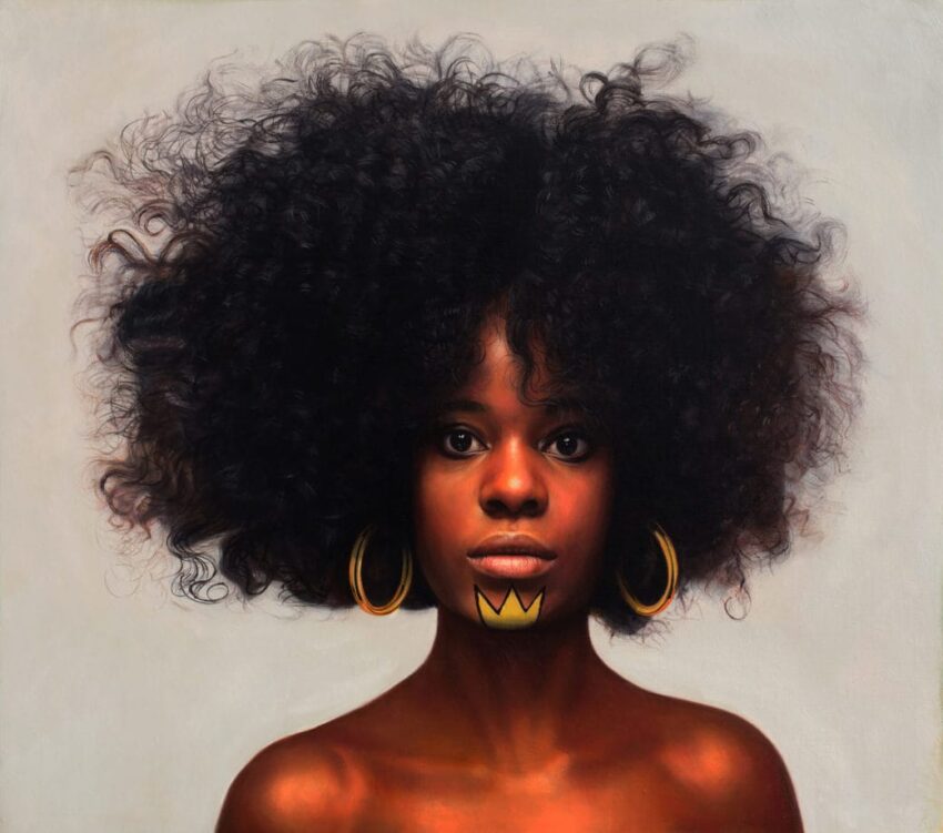 Portrait of a woman with large curly hair, wearing hoop earrings and a traditional-style lip decoration against a neutral background.