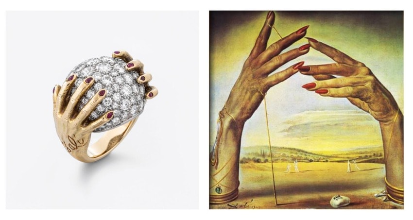 Gold ring with a hand-shaped design next to an artwork featuring hands with long red nails against a landscape background.