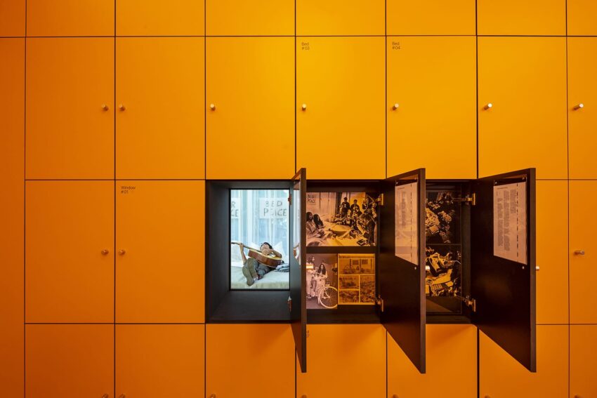 Yellow wall lockers with an open section displaying historical photos and documents.