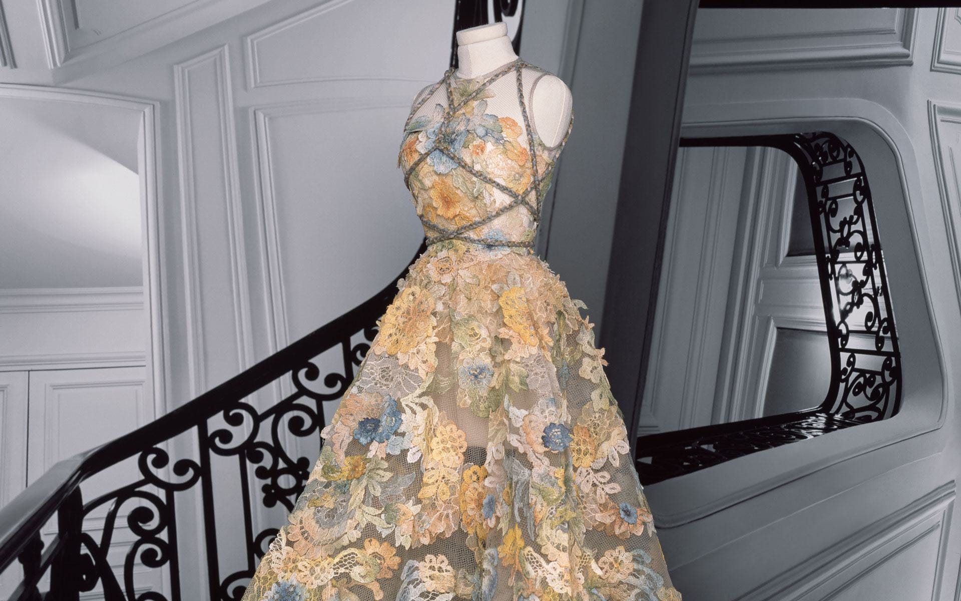 Dior’s Maria Elena Look: Bustier dress in turtledove gray tulle, with Chantilly lace appliqué composed of cerulean blue, saffron yellow, Falun red and jasper.