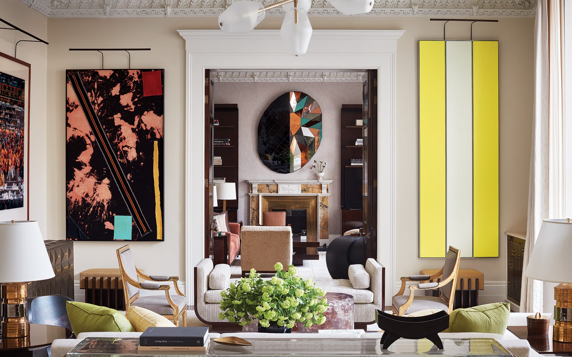 In the living room of a London residence that David Kleinberg Design Associates renovated in collaboration with architecture firm Donald Insall Associates, artworks by Sterling Ruby (left) and Tadaaki Kuwayama frame the view into the library where a mirror by Sam Orlando Miller is mounted above an antique mantelpiece.
