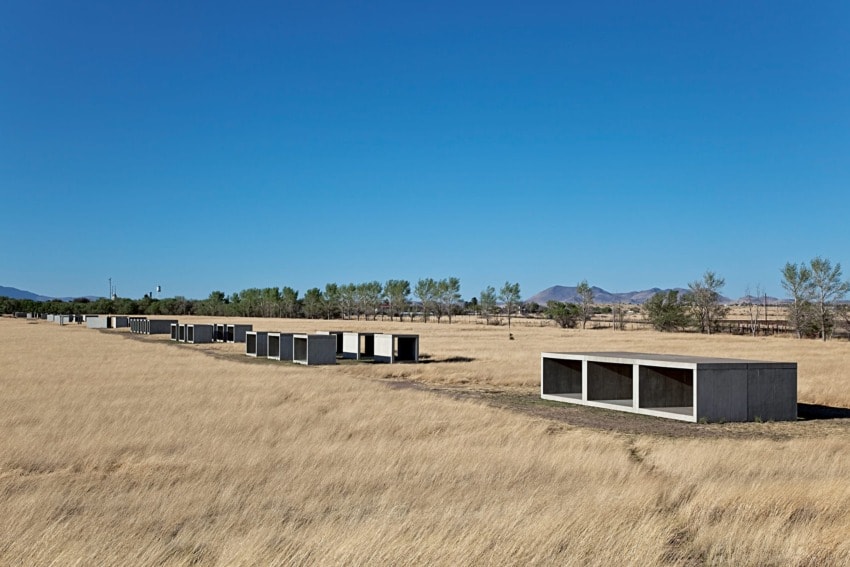 Rows of concrete structures in a grassy field under a clear blue sky.