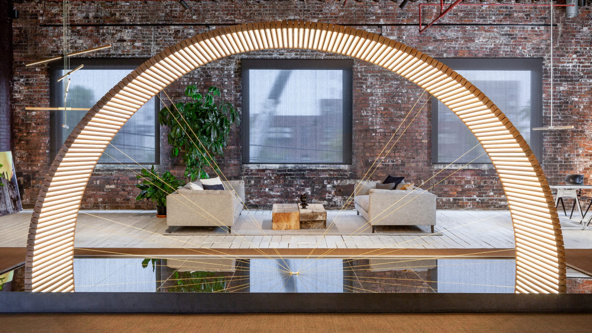 Decorative modern archway with seating area, plants, and art installations in an industrial-style room with exposed brick walls.