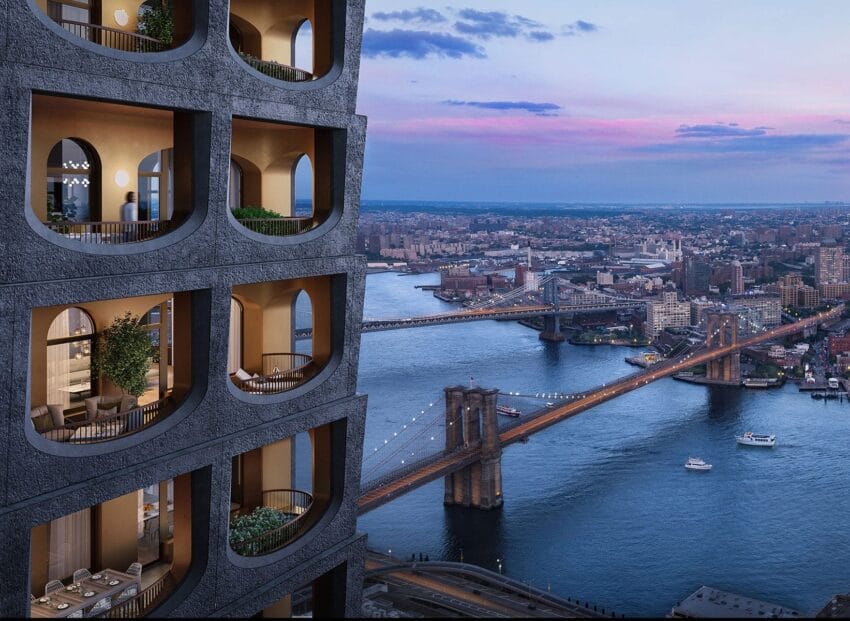 Apartment building with arched balconies overlooking bridges and a river at sunset in a cityscape.