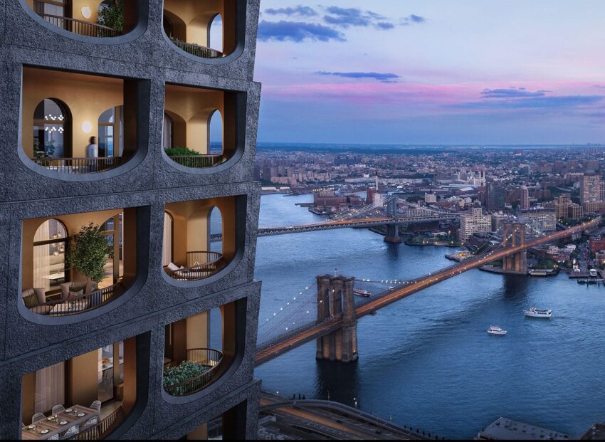 Apartment building with arched balconies overlooking bridges and a river at sunset in a cityscape.