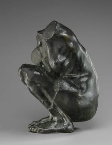 Bronze sculpture of a crouching figure with textured surface, capturing a sense of introspection and raw emotion.