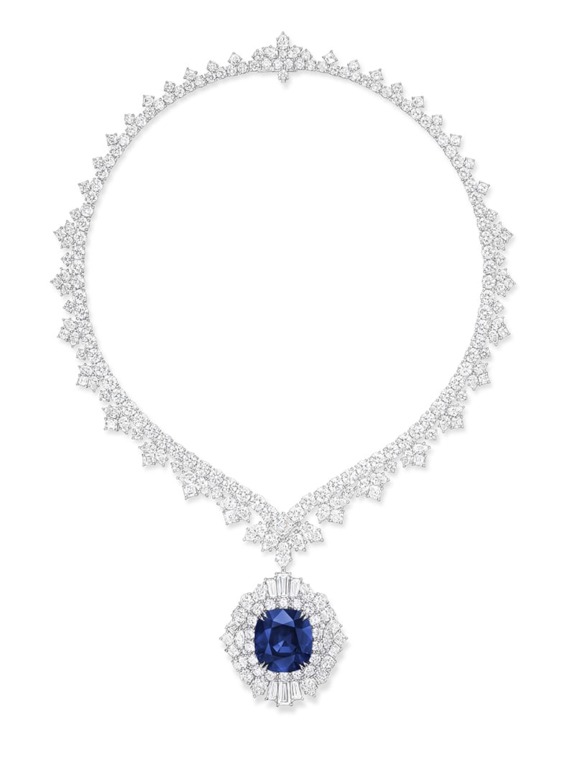Elegant diamond necklace with a large blue sapphire centerpiece displayed on a white background.