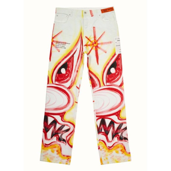 Colorful jeans featuring bold, abstract faces with red and yellow accents, set against a light background.